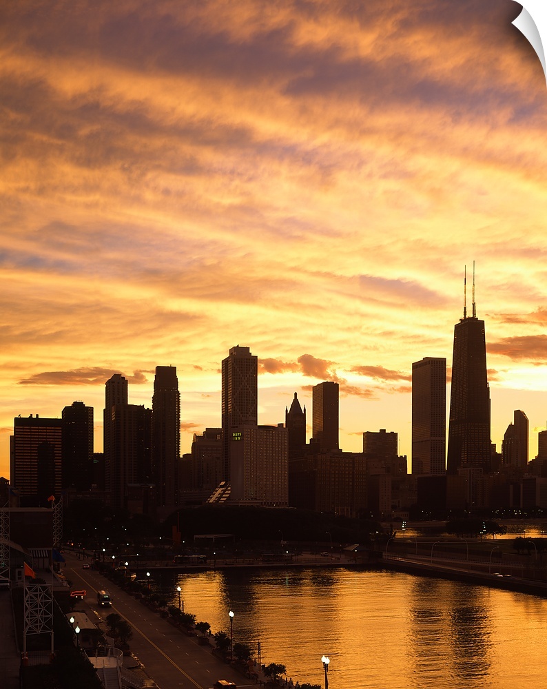 Giant, vertical photograph of the Chicago skyline and Navy Pier beneath a golden sky of wispy clouds at sunset.