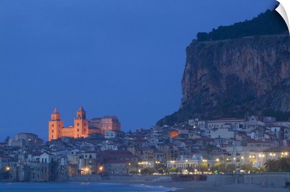 Large photograph includes a lively town on the coast of this famous island in Europe brightly shining in the night as the ...