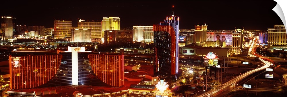 Horizontal photograph on a big canvas of Las Vegas, Nevada, brightly lit at night.