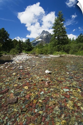Colorful rocks in Red Rock Creek, distant mountain peak, Glacier National Park, Montana