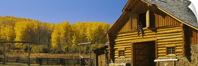 Cowboy sitting on a window of a log cabin Ouray County Ridgeway Colorado