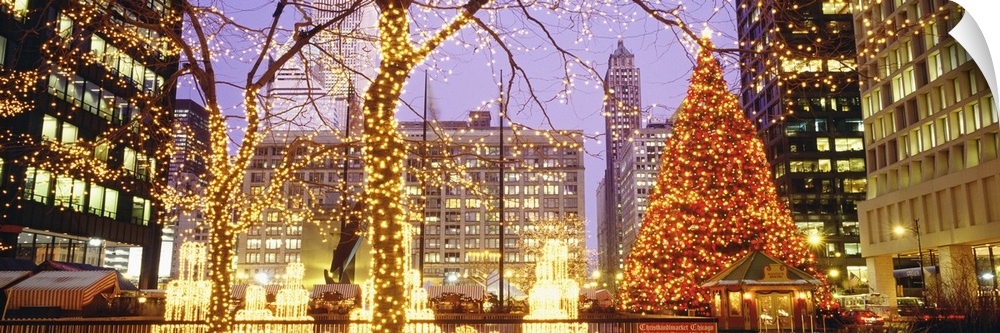 Panoramic photograph of Daley Plaza decked out with Christmas lights in the trees and a large Christmas tree sitting by th...