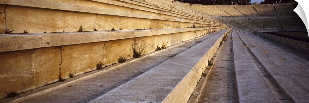 Panoramic photograph of wooden seats in ancient coliseum.