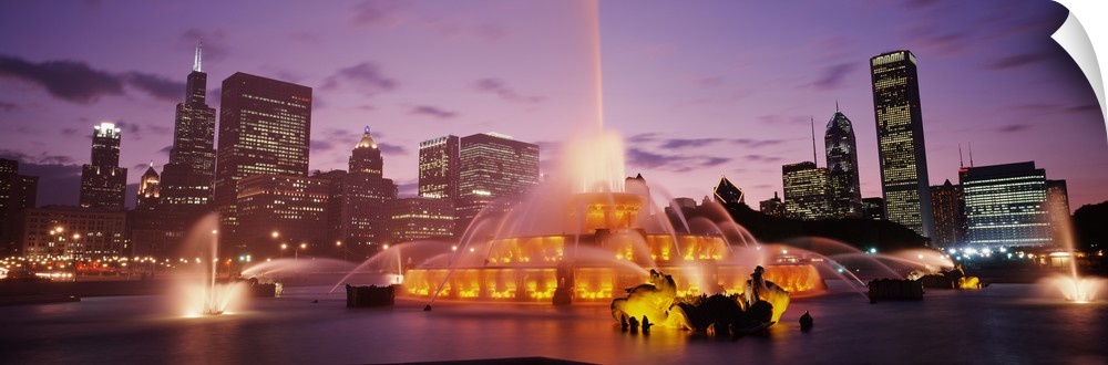 Panoramic photograph taken of Buckingham Fountain lit up at dusk as it sprays water in an intricate sequence.  Located In ...