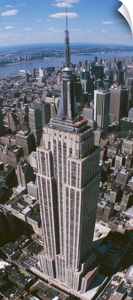Panoramic photograph taken from an aerial view focuses on a landmark skyscraper found within Manhattan as it overlooks the...
