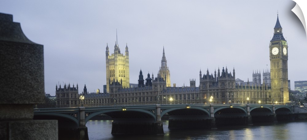 This photograph is taken of parliament and the big ben clock tower in London during dusk.