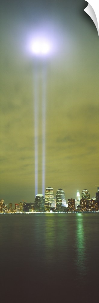 Vertical panoramic piece of a photograph of the lights shining up from where the twin towers stood.