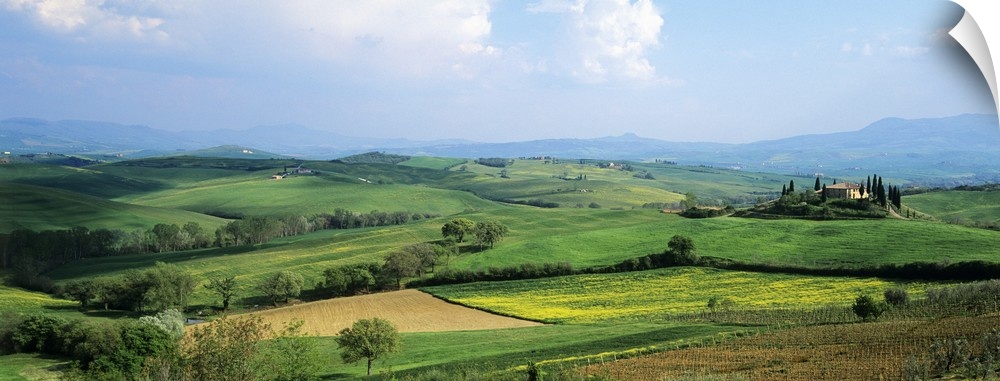 Vast land and large green fields in Italy are pictured in a wide angle view.
