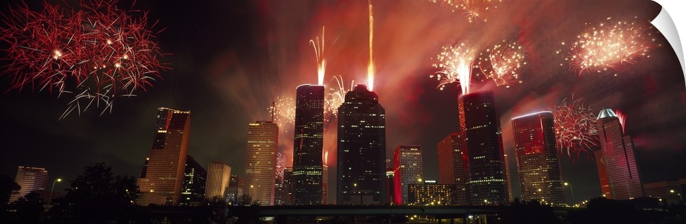 Fireworks explode in the night sky behind the backdrop of the Houston downtown skyline.