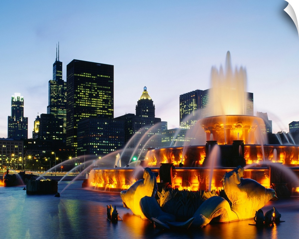 Huge photograph taken of Buckingham Fountain lit up at night as it sprays water in an artful sequence.  The background hol...
