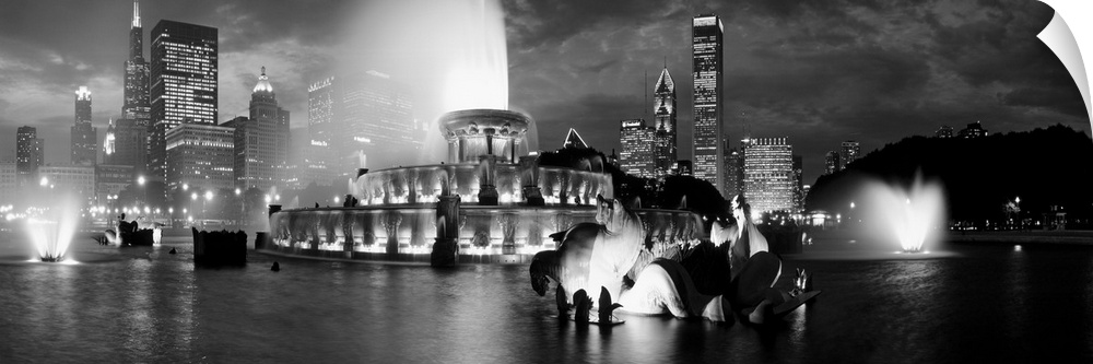 A panoramic photograph of the Chicago Skyline highlighting a large fountain in black and white.