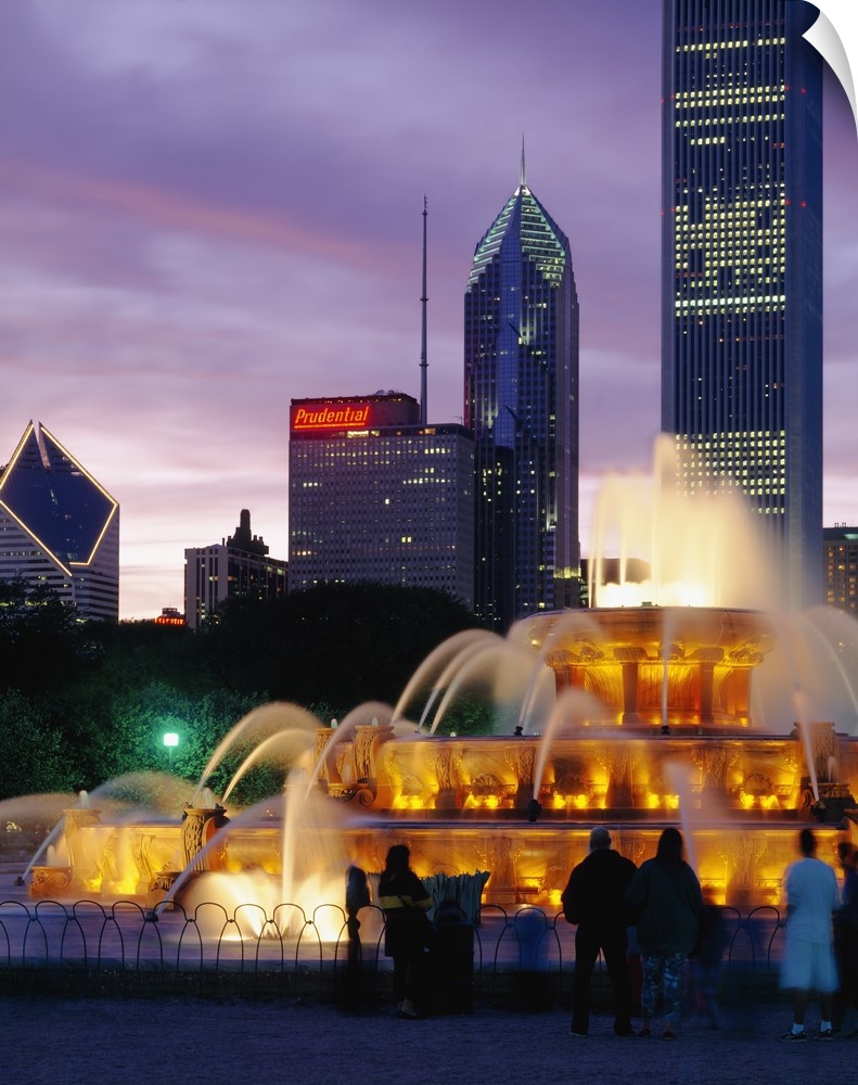 Vertical photograph on a large wall hanging of Buckingham Fountain, lit at night, in Grant Park, Chicago, Illinois.  Skysc...