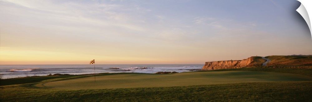 Panoramic photograph on a large canvas of the green on a golf course, along the coast of Half Moon Bay in California.