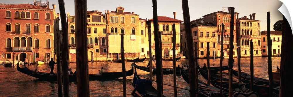 Panoramic photo of buildings along the canal in Venice, Italy at sunset.