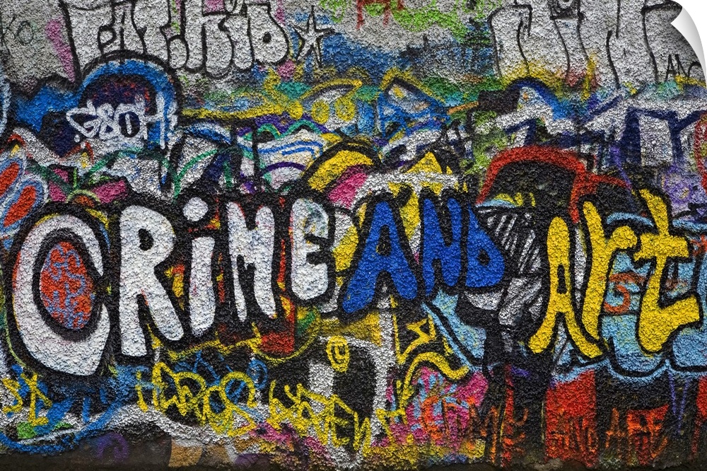 Panoramic photograph of colorful spray painted street art on a brick wall.