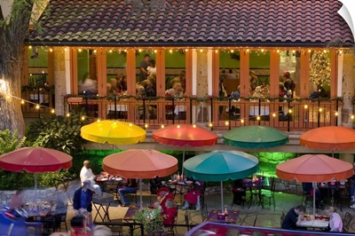Group of people in a restaurant lit up at dusk, San Antonio, Texas