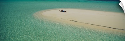 High angle view of a woman sunbathing on the beach, Maldives