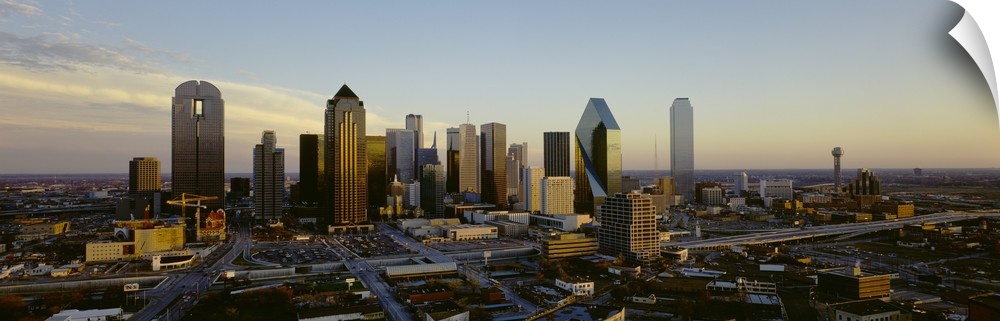 Buildings in the Dallas skyline are photographed in panoramic view during dawn.