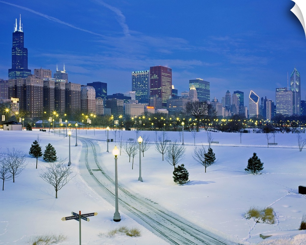 A photograph of a city park buried in fresh snow and the city skyscrapers available of as a large print.