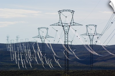 High voltage power lines spanning rolling hills.