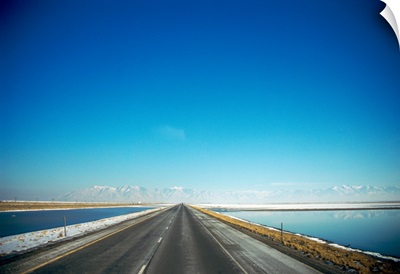 Highway along a lake with snow covered mountains in the background, Interstate 80, Tooele County, Utah