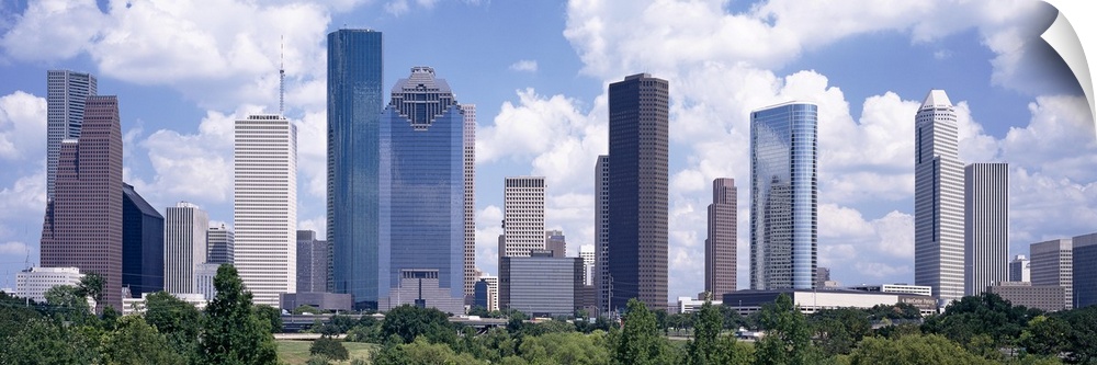 Giant, landscape wall picture of the Houston skyline, under a bright blue sky with many fluffy clouds.
