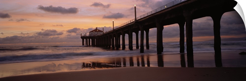 Wide angle photograph of Manhattan Beach Pier extending into the water at sunset, in Los Angeles County, California.