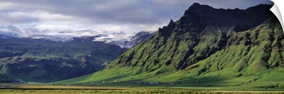 Iceland, South Coast, Sheer Basalt Cliffs, View of farm and cliff in the south coast