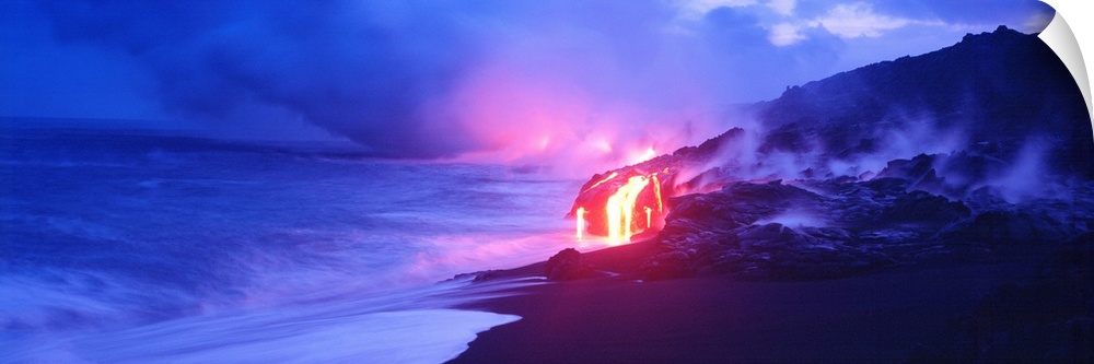 This panoramic photograph was taken at twilight and focuses on the glowing magma as it meets the sea and the air fills wit...