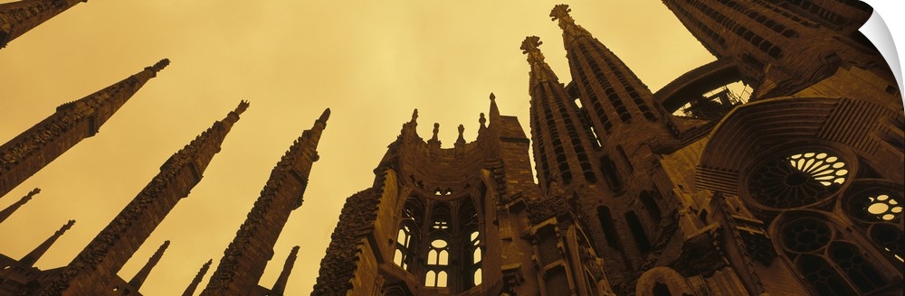A wide angle photograph is taken from the ground and looking up toward the top of the Sagrada Familia church.