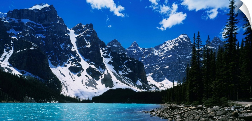 A landscape photograph of snow covered mountains surround a lake on this horizontal wall art.