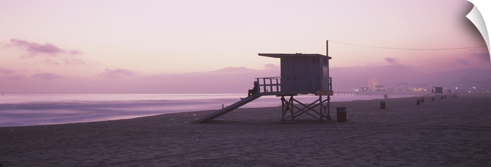 Long horizontal photo print of a lifeguard station on the beach along the Pacific ocean with the Santa Monica Pier in the ...