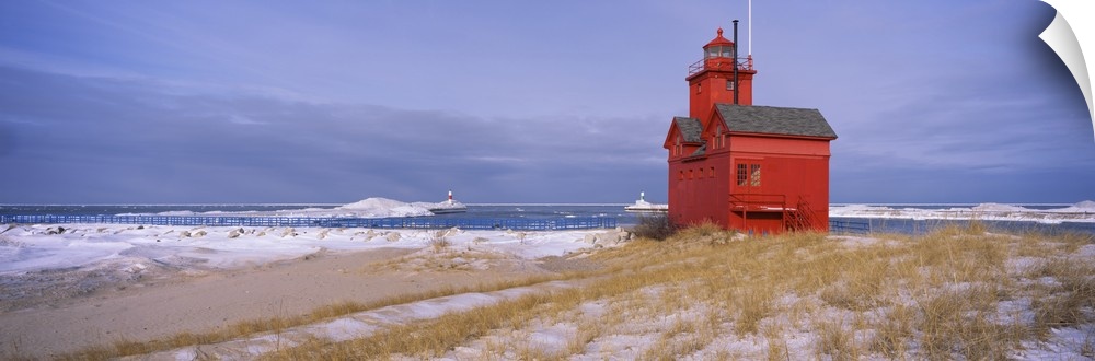 Big horizontal photograph of the Big Red Lighthouse against a blue sky, along the coast of Lake Michigan, in Holland, Mich...