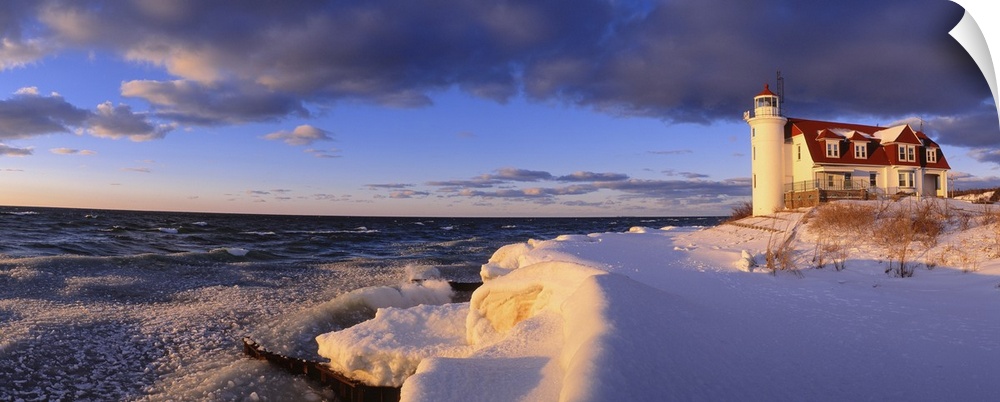 Panoramic photograph taken of a snow-covered beach on the edge of a large lake within the Midwestern United States.  Towar...
