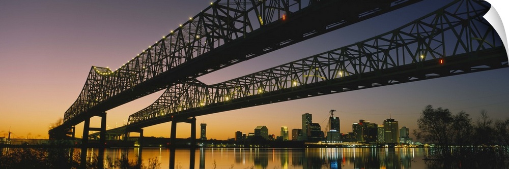 Large panoramic photograph taken beneath a long bridge running across a river in New Orleans, Louisianna (LA). The city sk...