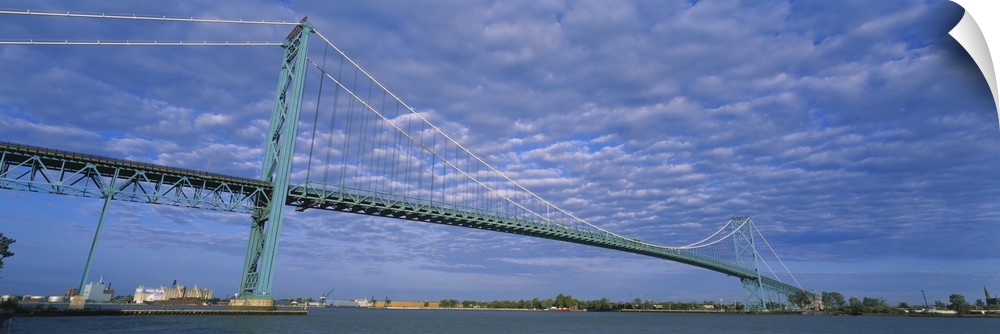 Long and horizontal image print of a long bridge spanning across the river in Detroit.