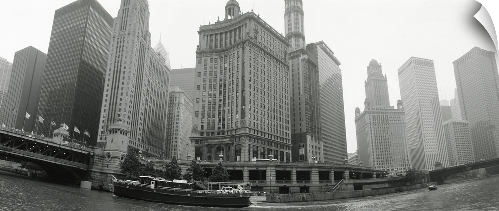 Large, horizontal photograph of boats and skyscrapers, taken at a low angle from the waterfront of Chicago, Illinois.