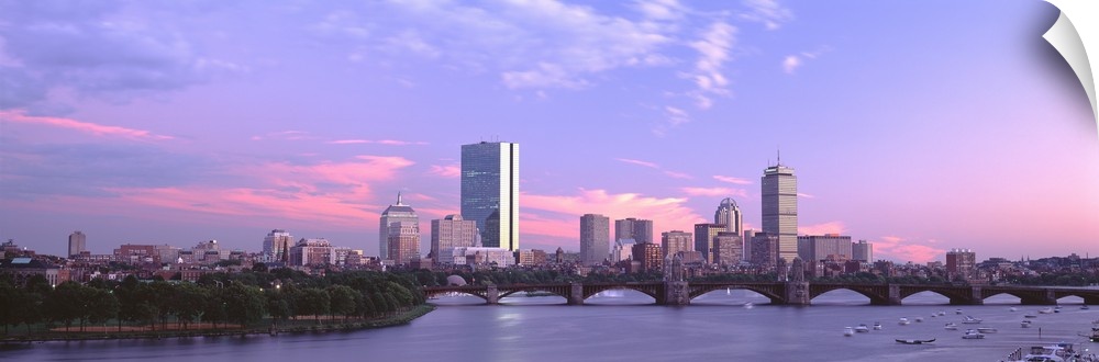 Landscape photograph of the Boston skyline beneath a vibrant sky at dusk, the Longfellow Bridge over the Charles River in ...