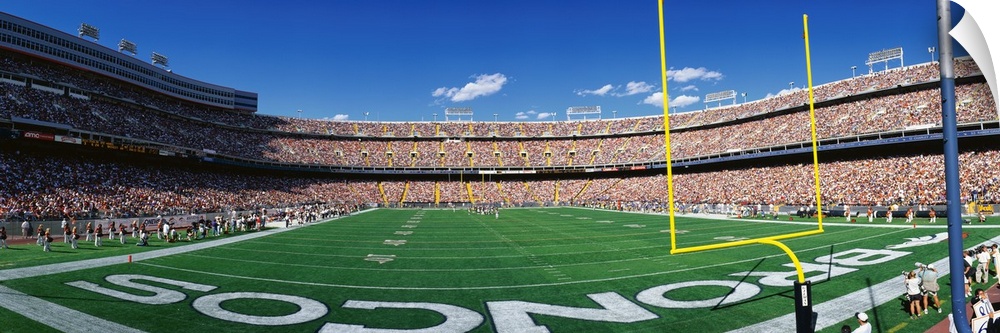 This is a wide angle shot of the broncos stadium taken from behind the end zone during a day game.