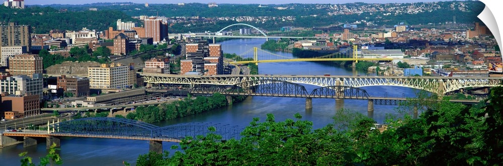 Big, horizontal, high angle photograph of numerous bridges crossing the Monongahela River, surrounded by the cityscape of ...
