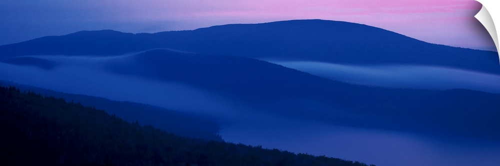 Panoramic photograph on a big wall hanging of shadowed mountains at sunset at Acadia National Park, in Maine.