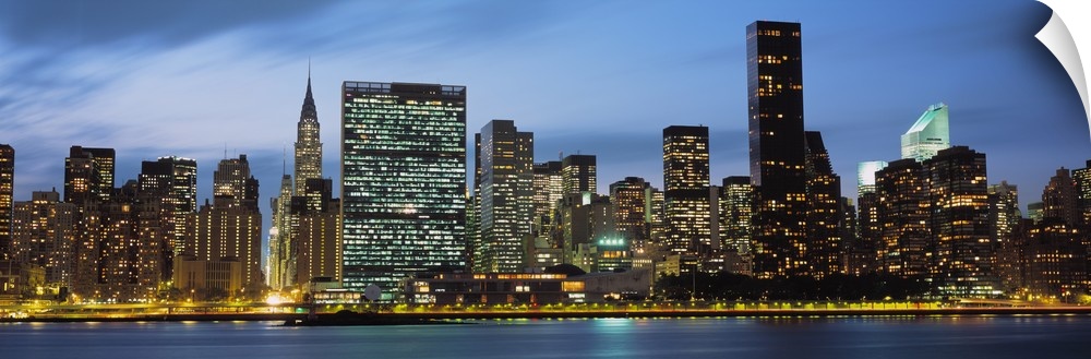 Giant, panoramic photograph of the New York City skyline lit up at night.