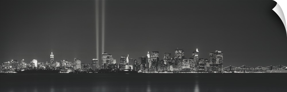 Panoramic vista of the New York City skyline in the evening, with beams of light from the World Trade Center tribute shini...