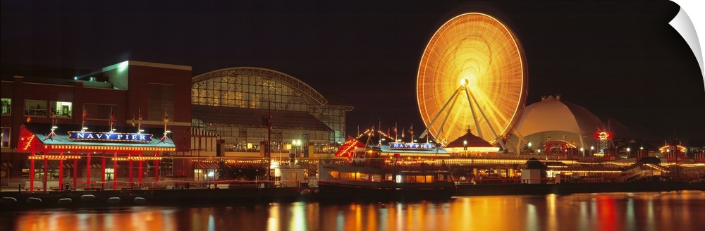 Panoramic photo on canvas of the navy pier lit up at night along a waterfront with a ferris wheel.