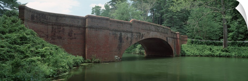 North Carolina, Asheville, View of a red brick arched bridge over river