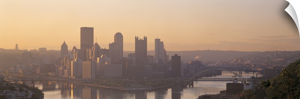 This is a panoramic photograph of the city skyline between two rivers becoming silhouetted in the late afternoon light.