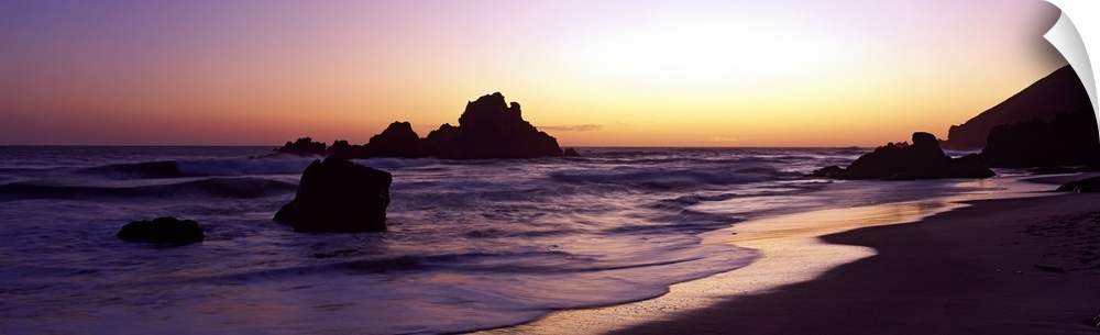 Sunset panoramic of the rocky beach in California.
