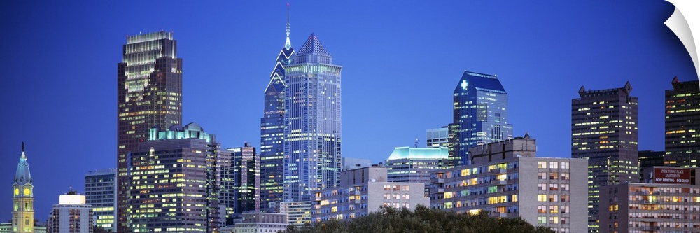 Panoramic photograph of the Philadelphia skyline during night with the buildings windows illuminated.