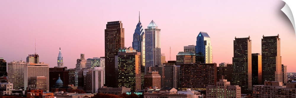 The skyline of Philadelphia, Pennsylvania against a hazy sunset sky.