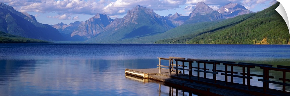 Dock on the water with mountains in the background at Lake McDonald Glacier National Park in Montana.